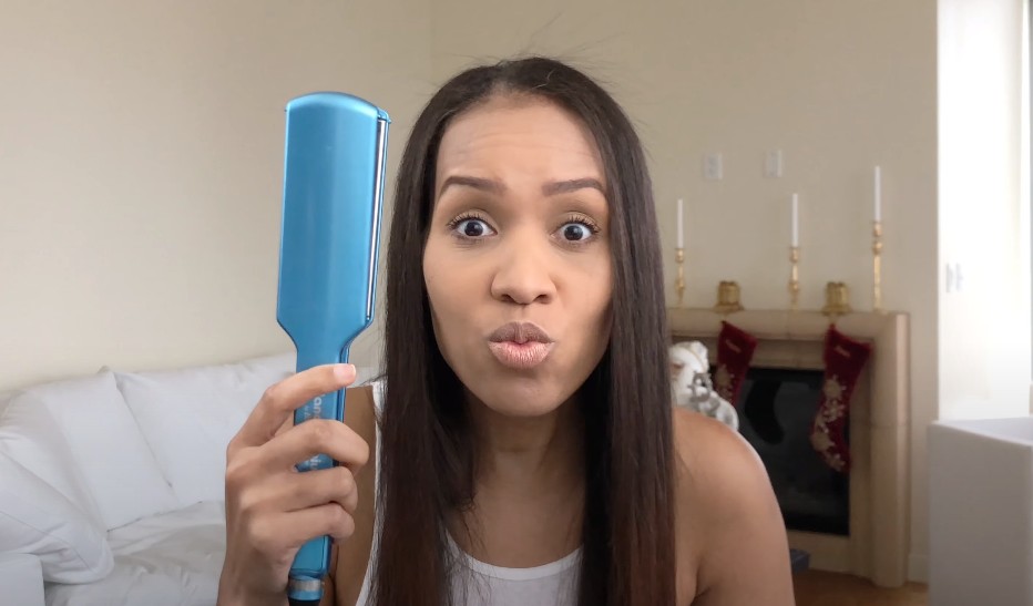 a girl with a 2 inch flat iron in hand