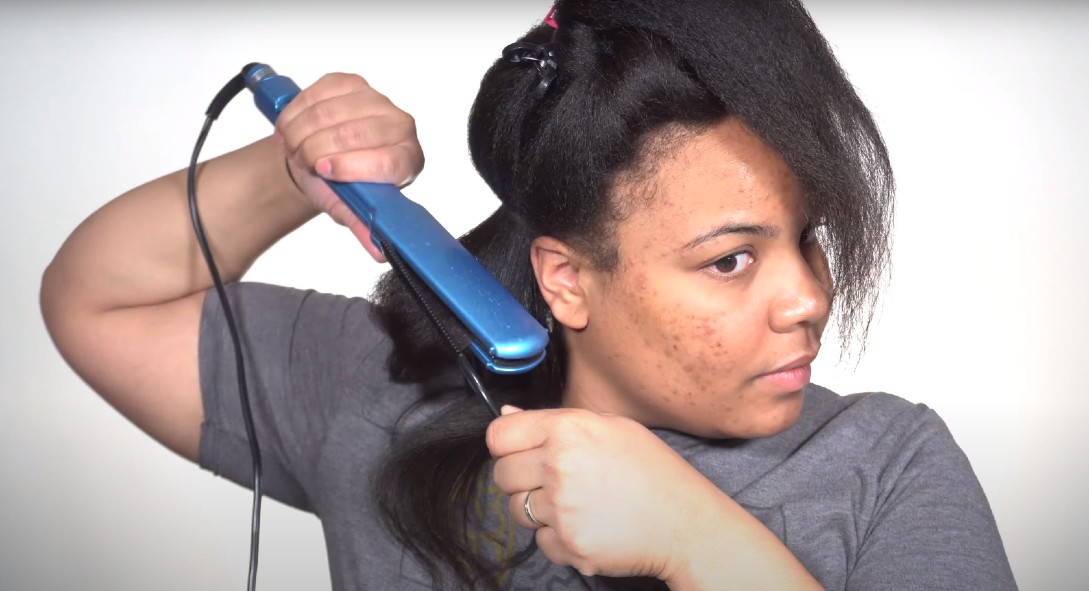 a woman straightening hair with babyliss flat iron
