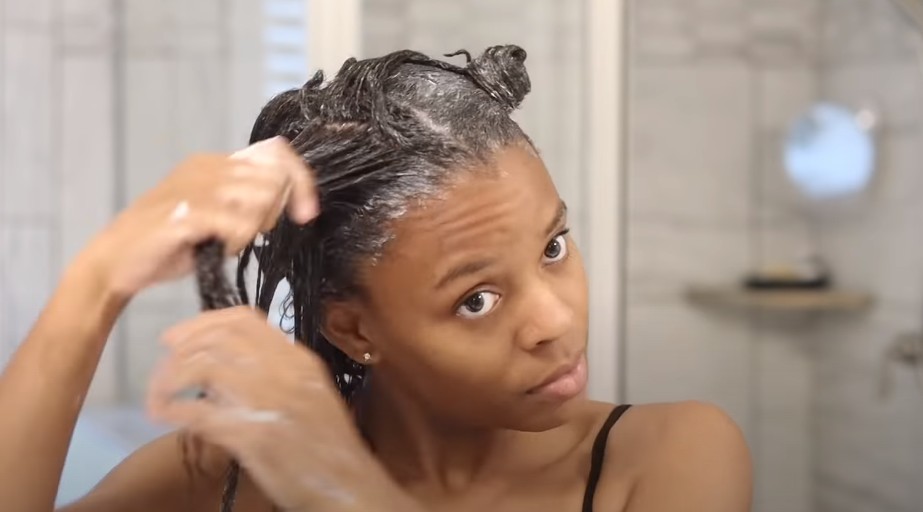 woman applying moisturizer to her hair