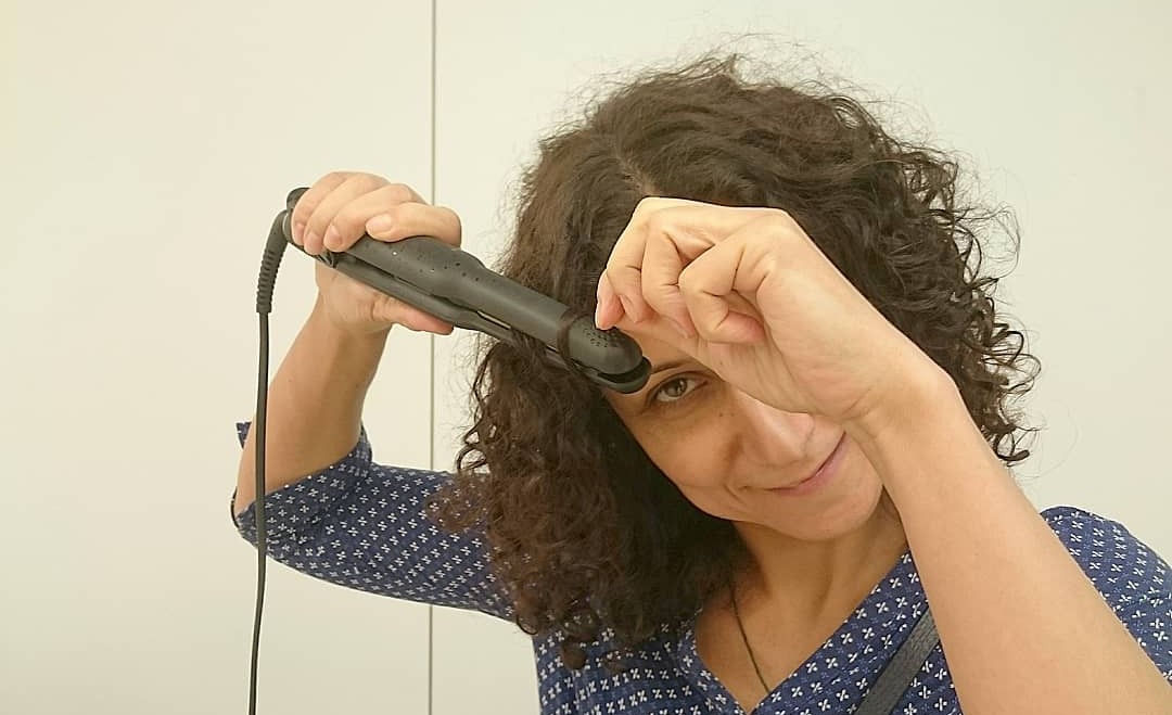 woman using a mini straightener from GHD
